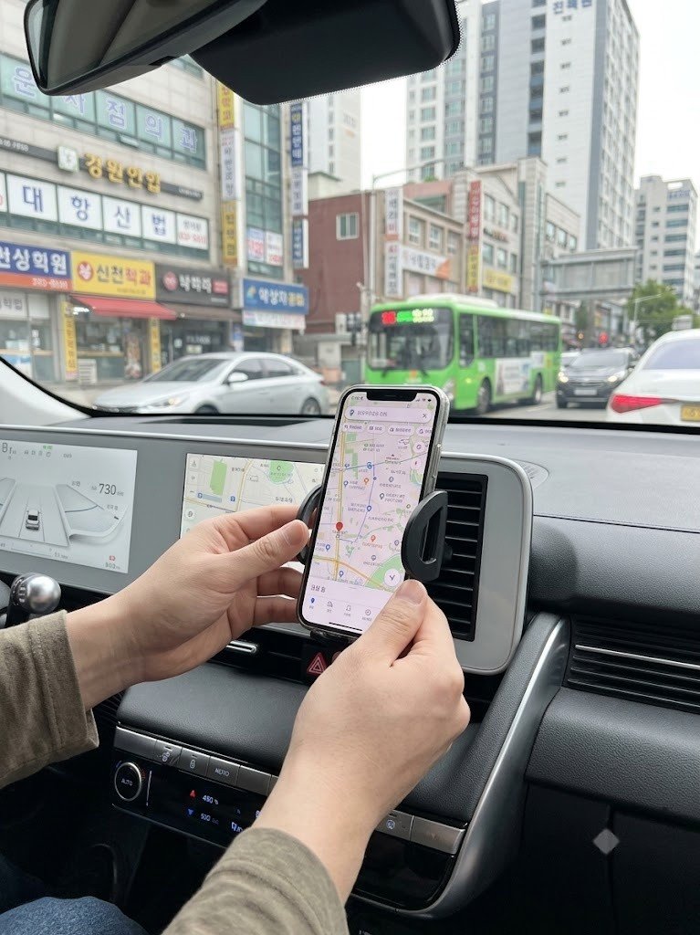 송풍구형 스마트폰 거치대를 조절하는 모습