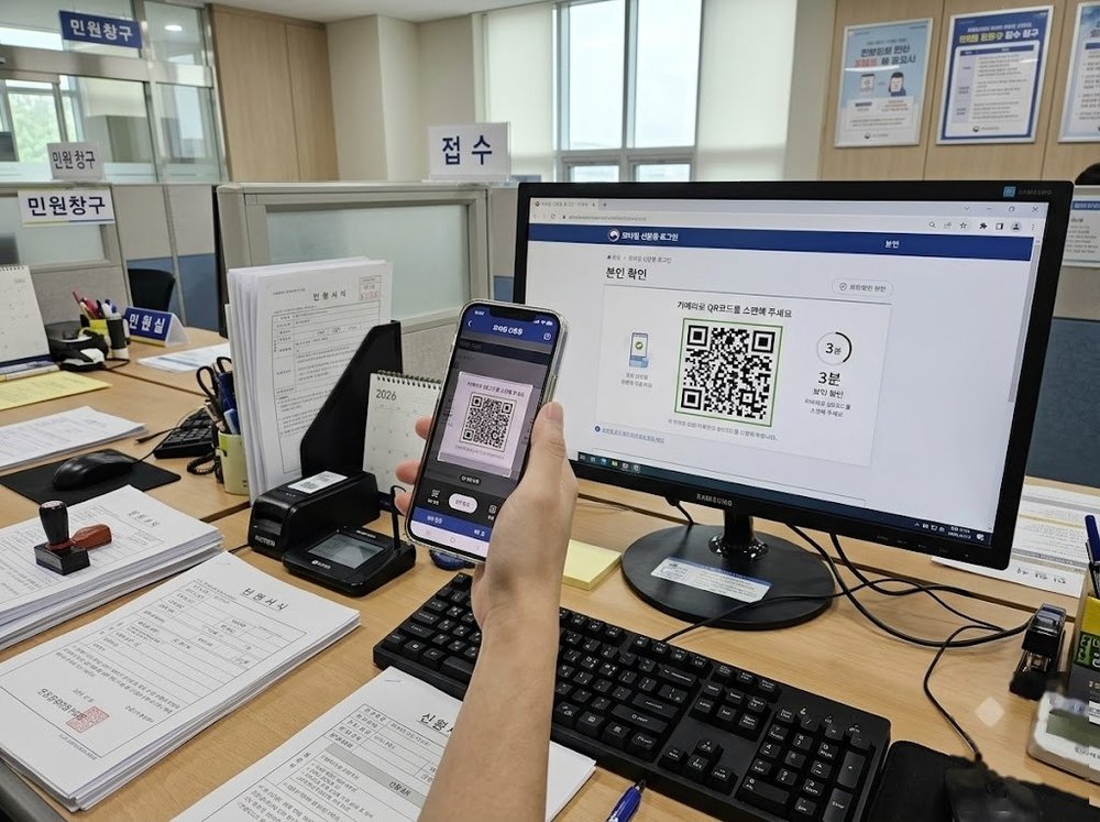관공서 창구에서 스마트폰으로 QR 코드를 스캔하는 모습